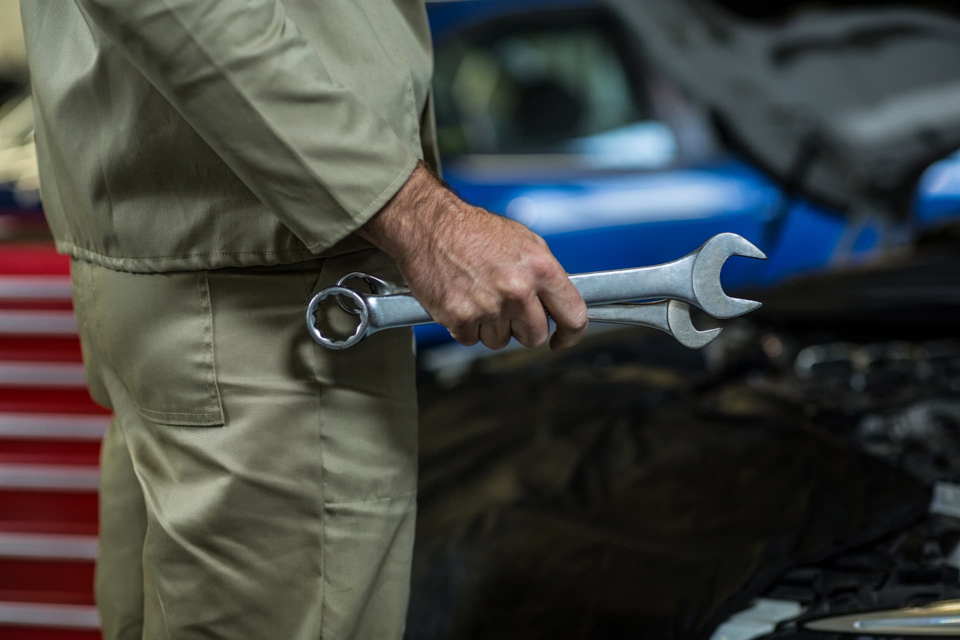 Service technician holding wrenches in a service bay — declined repairs that walk out the door